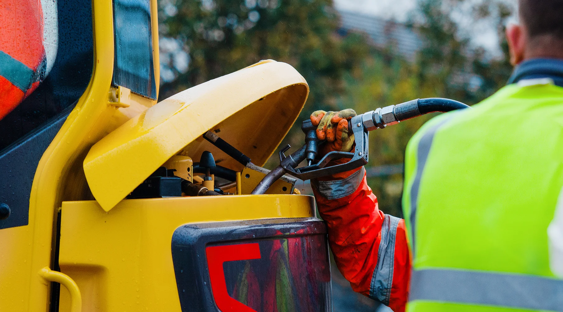 construction machinery being refilled while being supervised